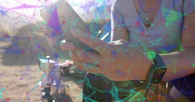 Woman wearing smartwatch checking smartphone next to bicycle on dirt path, digital network overlay