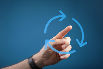 A hand pointing towards a circular arrow, suggesting concepts of process, cycle, and repetition on...