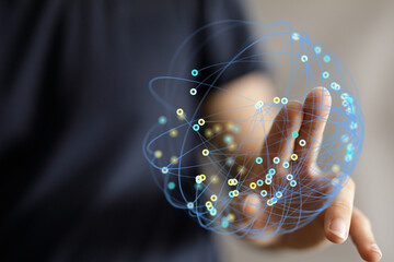 Hand reaching out to a digital network sphere, symbolizing connection, global communication, and...