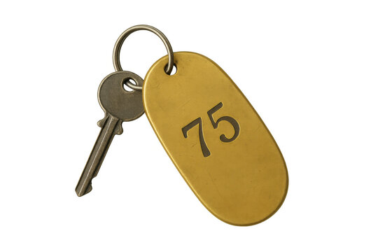 Vintage brass hotel key and number 75 keychain, concept of room access, retro stay, hospitality, or travel