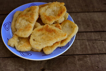 Traditional Bulgarian home made deep fried  patties  covered with sugar  оn rustic backgroud.Mekitsa or Mekica,  on wooden  rustic  background. Made of kneaded dough that is deep fried 