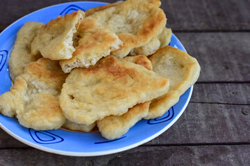 Traditional Bulgarian home made deep fried  patties  covered with sugar  оn rustic backgroud.Mekitsa or Mekica,  on wooden  rustic  background. Made of kneaded dough that is deep fried 