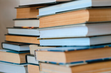 Stack of hardcover books with visible pages and spines, symbolizing education, knowledge, and literature.
