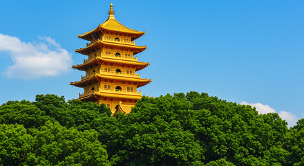 Golden Pagoda Tower Amidst Lush Green Trees Under Blue Sky