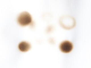 Burned paper with black scorch stains and aged texture. Paper burned with black marks. Old stained paper showing fire damage and discoloration.