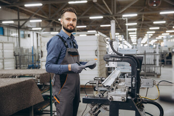 Factory worker operating machinery for aluminum and pvc windows and doors production