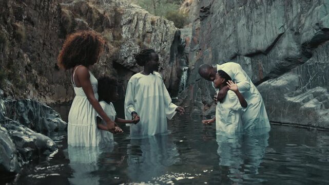 Ceremony pool baptism ritual in nature with family connections and joy