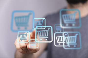 Person interacting with shopping cart symbols, illustrating online retail and e-commerce. Perfect...