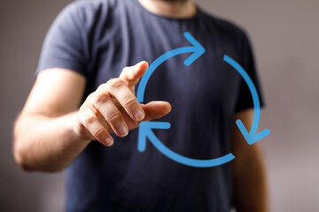 Close-up of a man's hand pointing at a circular arrow diagram, representing processes, renewal and feedback loops. Perfect for business and tech
