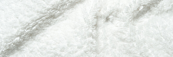 Soft white textile fabric with fluffy texture and gentle folds close-up background.