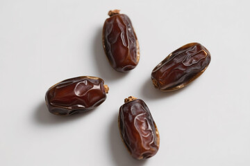 Fresh, natural, brown dates with wrinkled surface scattered on pure white background, highlighting plump texture, glossy sheen, and organic food concept for healthy eating.