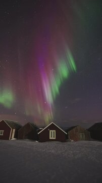 Timelapse view of green aurora with full-moon dancing over Malangen Fjord