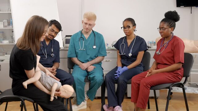 Medical students learning cpr on a baby mannequin