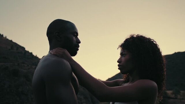 Intimate hug between two people during sunset in a serene outdoor setting
