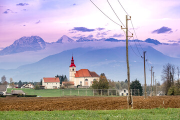 Church and mountains under a purple sky.