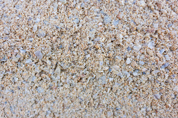 Close up texture of fine light sand with small stones and grains, natural neutral background, macro shot of dry sandy surface, beach or construction material pattern, summer and autumn concept