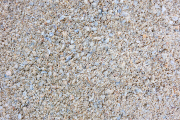 Close up texture of fine light sand with small stones and grains, natural neutral background, macro shot of dry sandy surface, beach or construction material pattern, summer and autumn concept