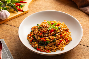 Stir fried instant noodles with minced pork and holy basil leaves in a plate.Thai spicy food.