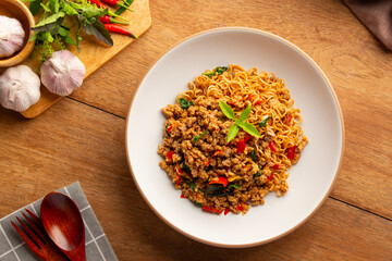 Stir fried instant noodles with minced pork and holy basil leaves in a plate.Thai spicy food.Top view.