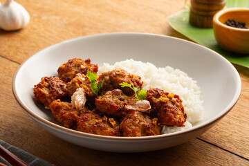 Fried Pork Balls(minced pork) with Garlic and Pepper and cooked rice in white plate.