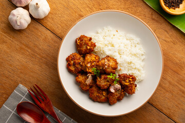 Fried Pork Balls(minced pork) with Garlic and Pepper and cooked rice in white plate.