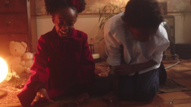 Kids having fun playing marbles indoors at home during evening time