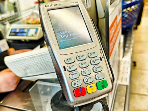 Kirov, Russia - July 21, 2025: Payment transaction at a checkout with a card reader device in a busy retail store