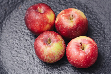 Fresh red apples on dark background. Healthy fruits full of vitamins and natural sweetness. Organic food concept symbolizing nutrition, freshness, and seasonal harvest.