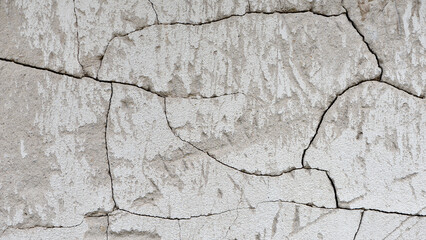 clay wall. the old clay wall is crumbling. surface wall for vintage background. Wall texture for background. old cracked plaster, grey cement floor, needs repair, restoration