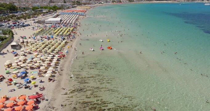Aerial view of the beach at San Vito Lo Capo, located in the province of Trapani, Sicily, Italy. There are many beach resorts and parasols with tourists on holiday.