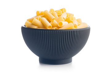 Uncooked rigatoni pasta in bowl isolated on white background.