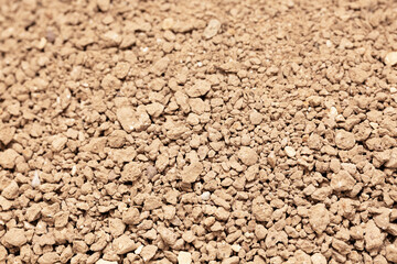 Textured brown cat litter granules emphasize natural absorbent materials suitable for pet care.