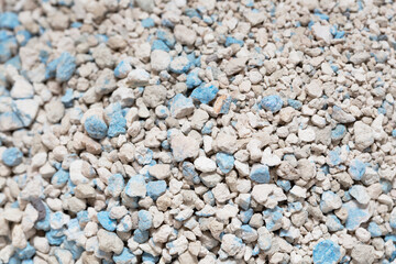 Textured  cat litter granules at litter with blue flecks. emphasize natural absorbent materials suitable for pet care.