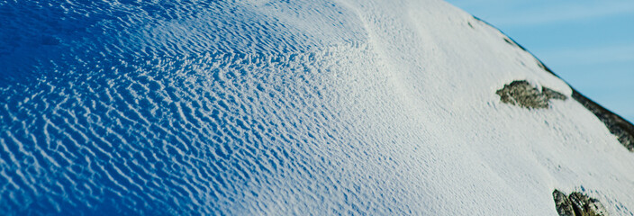Fototapeta premium Closeup of textured snow surface in winter sunlight.