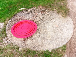 Fire hydrant under a red manhole cover