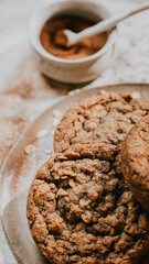 A plate of cookies with a jar of cinnamon on the table