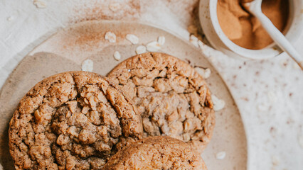 Three cookies on a plate with a bowl of brown sauce next to them
