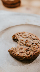 A cookie is on a plate with a bite taken out of it