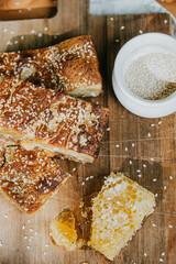 A plate of sesame bread and a jar of sesame seeds sit on a wooden cutting board