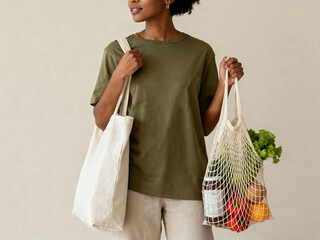 Woman carrying reusable mesh grocery bag with vegetables and fruits and a cotton tote bag against beige background