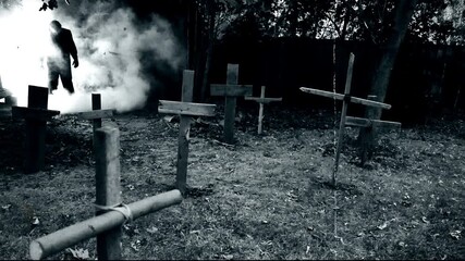 A zombie walking through a rustic cemetery graveyard with crosses and smoke. Classic suspense horror or Halloween film theme. Edited with vintage silent film effects. - Powered by Adobe