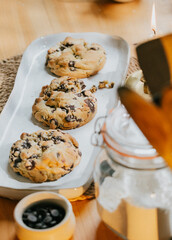 Three chocolate chip cookies on a white plate