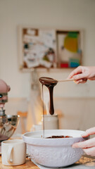 A person is making chocolate sauce in a bowl