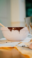 A white bowl with chocolate sauce on it