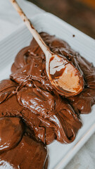 A spoon is scooping chocolate from a pan