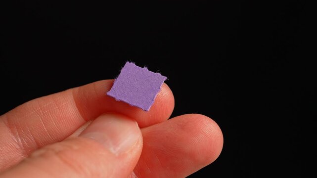LSD Psychedelics therapy and Lysergic acid experiments. Hallucinogenic drug oral consuming and mental health. Man holding LSD strip blotter with dry drop of Lysergic acid in self treatment.