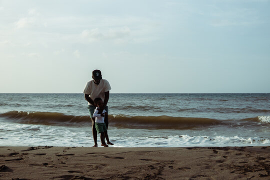 Father teaching son playing in ocean waves - Powered by Adobe