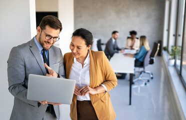 Multicultural professional businesspeople working together on research plan in boardroom.
