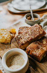 A plate of honey and sesame bread sits on a wooden table