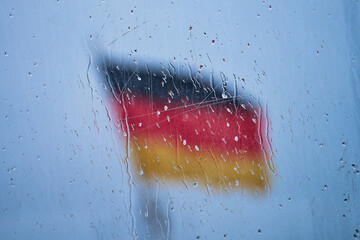 German Flag behind glass with raindrops. High quality photo
